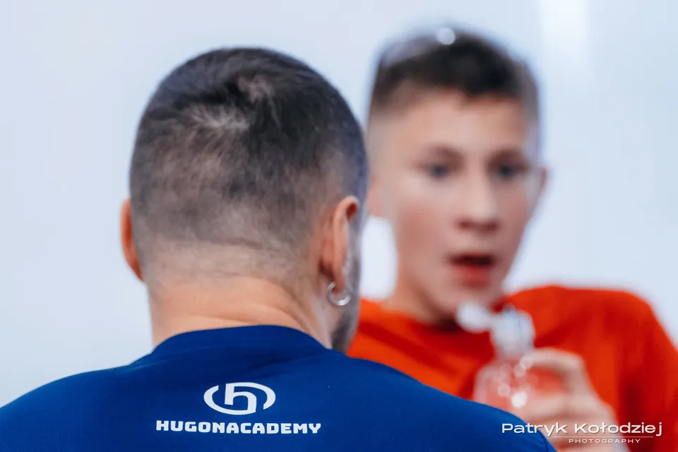 Rozmowa przy korcie w koszulce HugonAcademy
