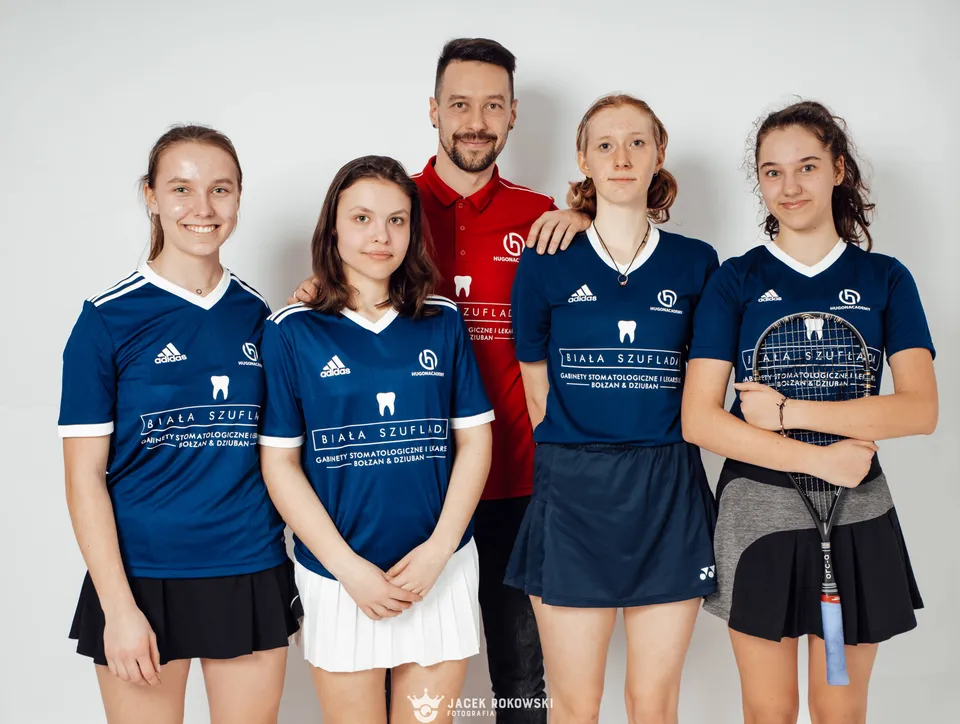 Grupa zawodniczek i trener na wspólnym zdjęciu